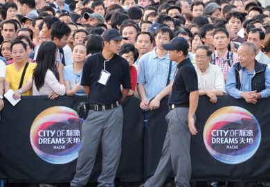 People wait for the opening of a new casino outside the City of Dreams complex in Macau to illustrate University of Macau edging us out, international academics fear