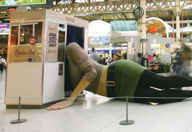 A giant statue of a female figure sprawled across Victoria train station's concourse, her upper body squeezing into a photobooth as a metaphor for the Treasury using a lower cap to reduce the outlying on student loans.