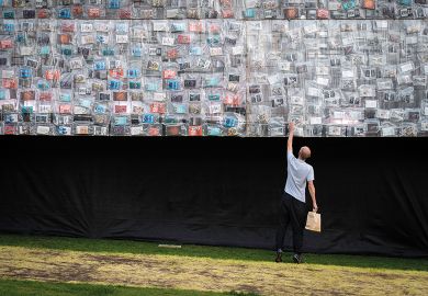 A visitor looks at a book on the side of the Big Ben Lying Down installation to illustrate Forget book deals if REF open access rules proceed, warn scholars