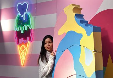 A visitor to Sugar Republic poses in front of a giant ice cream in Melbourne to illustrate ‘Sweet spot’ spending tipped for Australian budget
