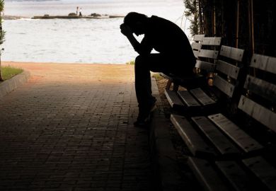 Silhouette of person sitting on a bench as a metaphor for The burned-out suffer in silence