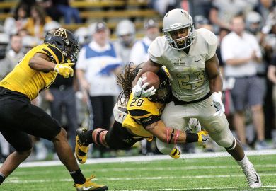 Running back Aaron Duckworth of the Idaho Vandals carries a tackler with him during first half action against the Appalachian State Mountaineers to illustrate Pushback mounts as Idaho nears Phoenix purchase