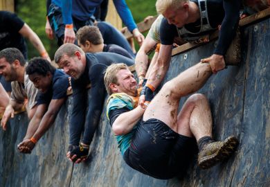 people helping each other to climb wall