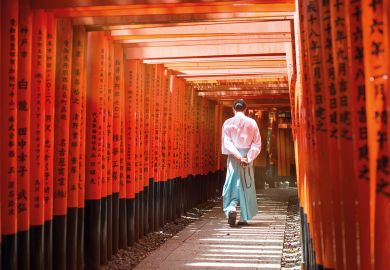 Monk walking in Fushimi inari shrine path of torii, Kyoto, Japan. Monk walking in Fushimi inari shrine path of torii, Kyoto, Japan to illustrate Japan expected to lose 140,000 students by mid-century