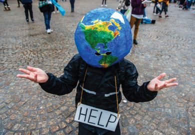 A man with an earth ball on his head and help sign makes hand gesture