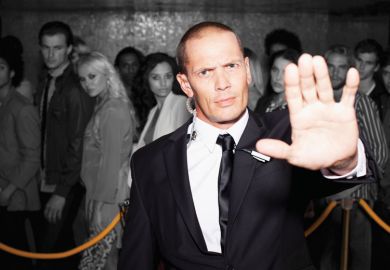 Bouncer with arm outstretched outside nightclub