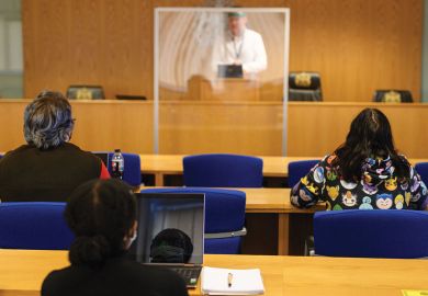 ecturer Ian Bowden teaches law students wearing face coverings to help mitigate the spread of the novel coronavirus .