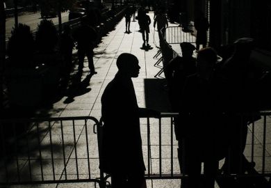 people walking with barricades and officers at the entrance 