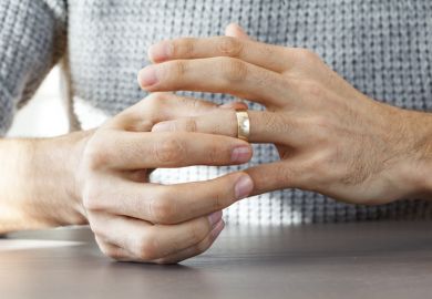 A man removes his wedding ring, symbolising exclusive partnerships