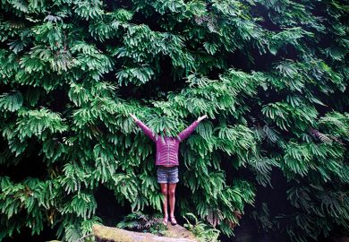 Woman hides her face in plant