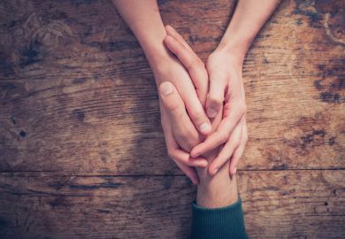 Woman holding man's hand providing support/kindness Woman holding man's hand providing support/kindness