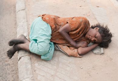 Woman lying on pavement, Delhi