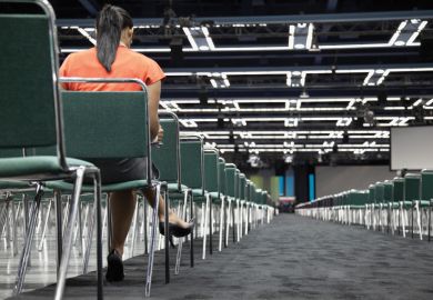 Woman sitting alone in empty conference centre