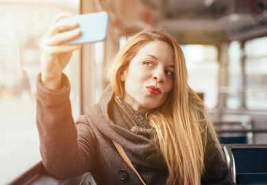 Woman taking selfie photograph with smartphone