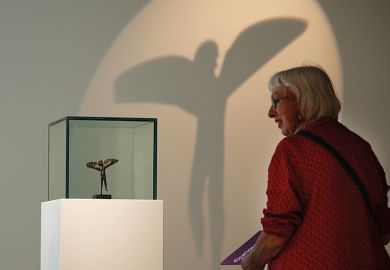 A woman looking at an item in a museum