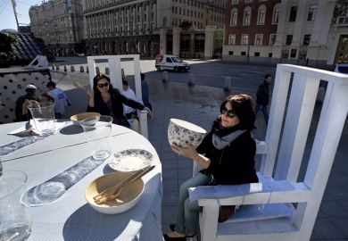 Women sit at giant table Women sitting at giant table