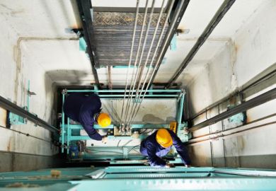Workmen repairing a lift
