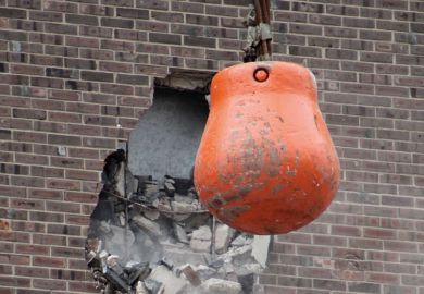 Wrecking ball demolishing wall