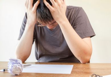 Student holding head in hands Student holding head in hands