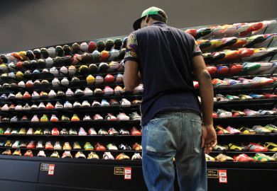 Young man looking at store display of sneakers/trainers Young man looking at store display of sneakers/trainers