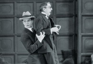 Young man picking up and carrying older man