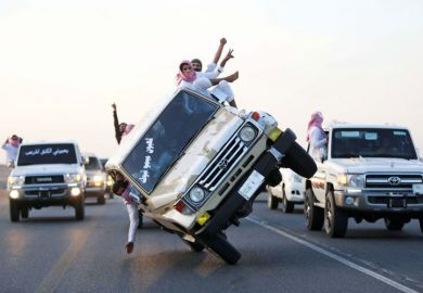 Young men driving on two wheels