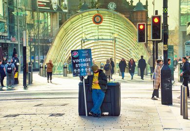 Young person holding a sandwich board advert, Glasgow. To illustrate that most students are employed in low-paid jobs. 