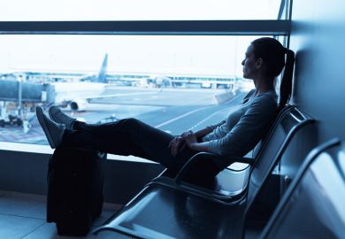 Young woman seated in airport departure lounge