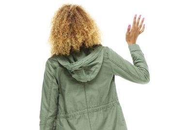 Young woman waving away from camera Young woman waving away from camera