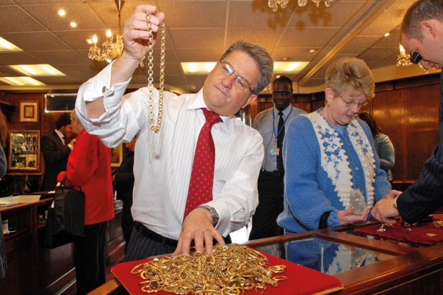 A man inspecting gold jewellery A man inspecting gold jewellery