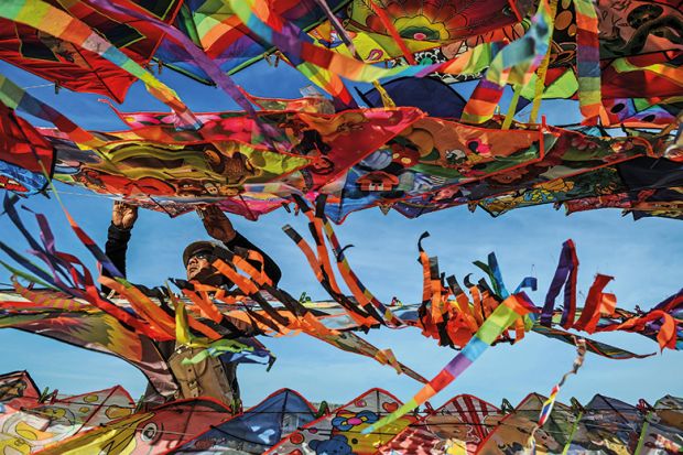 A man surrounded by colourful kites