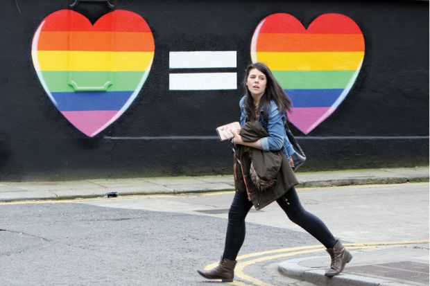 Woman walks past mural in favour of same-sex marriages