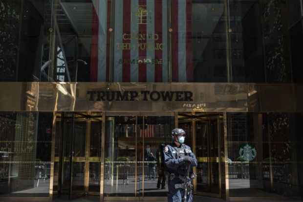 A counter-terrorism officer wearing a face mask stands at the entrance of Trump Tower