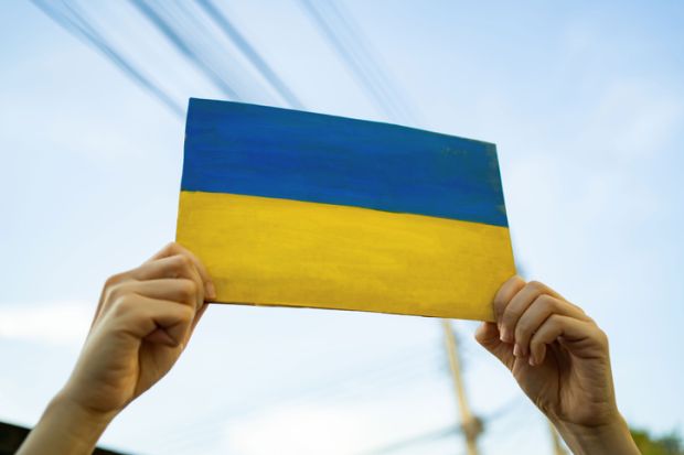A man holding cardboard painted into Ukraine flag