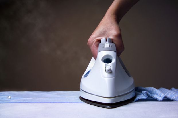 A steam iron ironing a shirt, representing smoothing out inequality