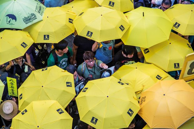 Activists hold yellow umbrellas outside Hong Kong Central Government Complex