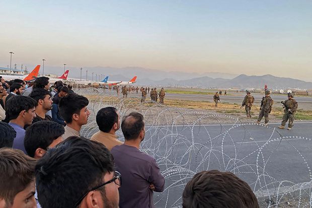 Afghans crowd at the airport as US soldiers stand guard in Kabul in August 2021
