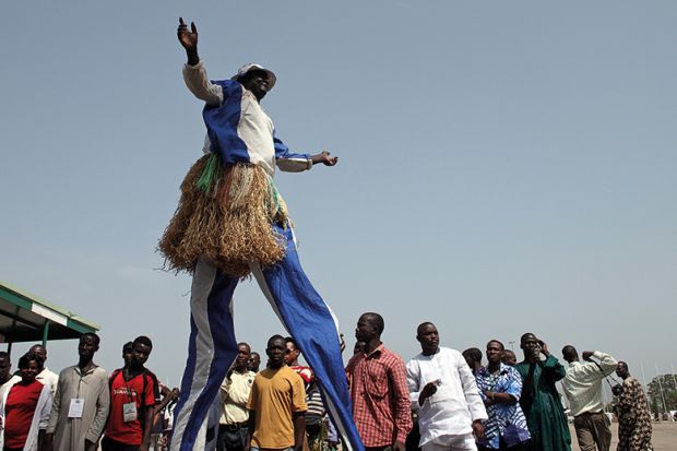 A participant on stilts performs during the Abuja Cultural Carnival in Nigeria. To illustrate Africa rising in the World University Rankings