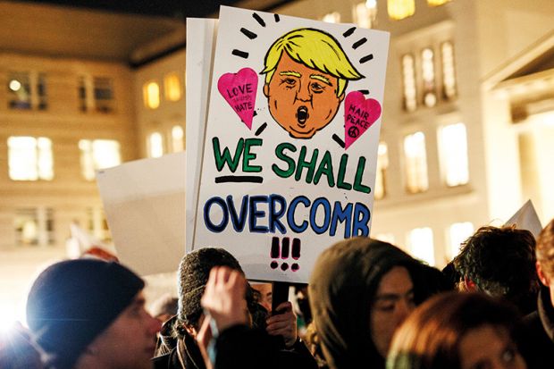 Anti-Trump demonstrators holding placard