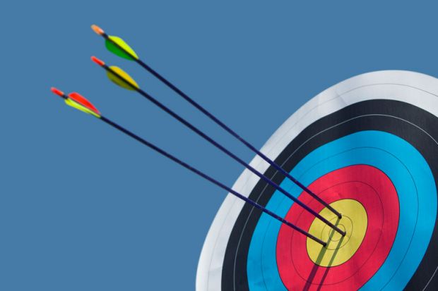 Arrows shot into archery target bullseye