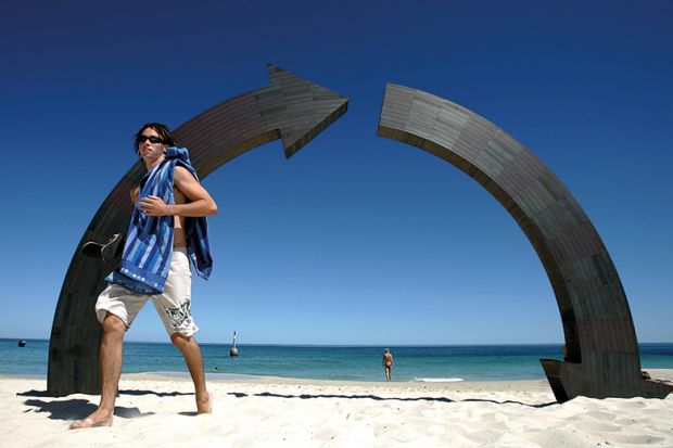 A swimmer walks past "Roundabout" a sculpture by Jennifer Cochrane of Western Australia  to illustrate Losses on the home front proving costly for Australian universities