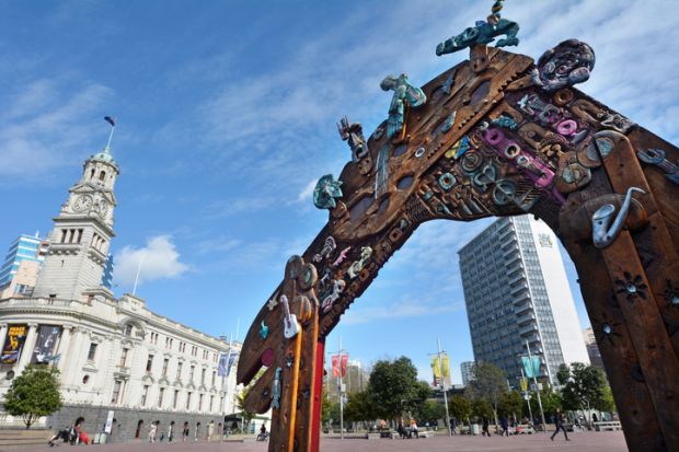 Auckland, New Zealand - August 10, 2015 People walk near a Traditional Maori entry gate at Aotea Square. Its one of the biggest squares in New Zealand used for open-air concerts, gatherings, markets and political rallies.