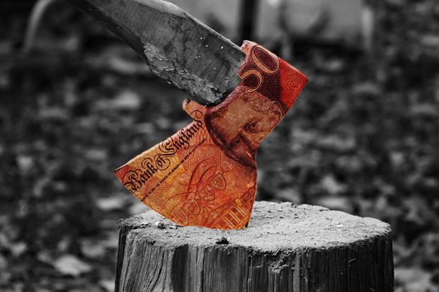 Axe on a block of wood with £50 banknote on the axe head. To illustrate the cost of severance pay. Axe on a block of wood with £50 banknote on the axe head. To illustrate the cost of severance pay.