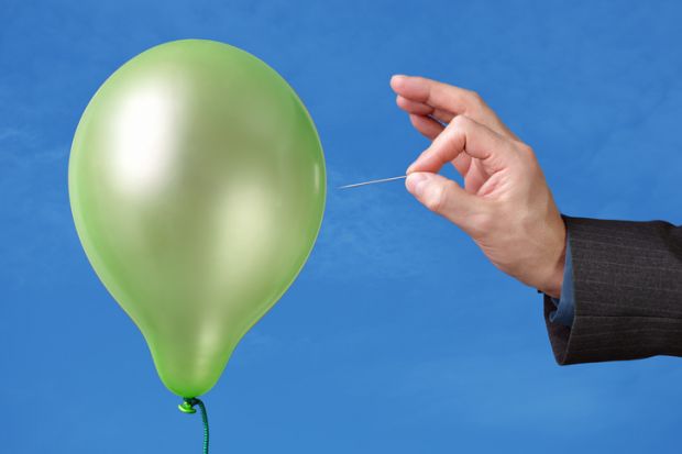Hand bursting a balloon