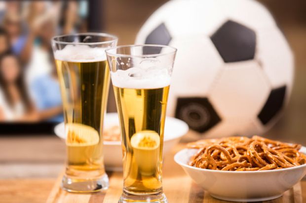 Beer, pretzels and football on pub table