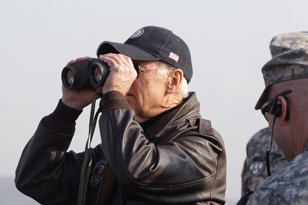 Joe Biden looks through binoculars toward North Korea