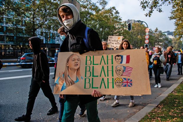 Person with placard with Greta Thunberg’s blah blah blah quote 