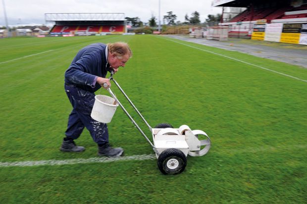 Man painting lines on a pitch Man painting lines on a pitch