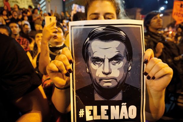 Woman holds poster of Jair Bolsonaro