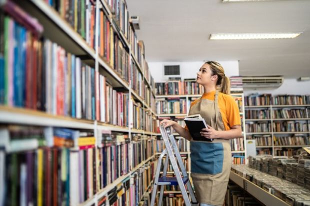 A student stacks bookshelves in a shop A student stacks bookshelves in a shop